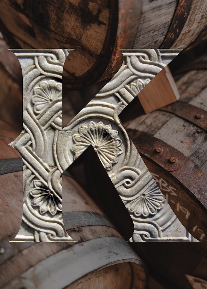 Ornate Knappogue K emblem over aged whiskey casks